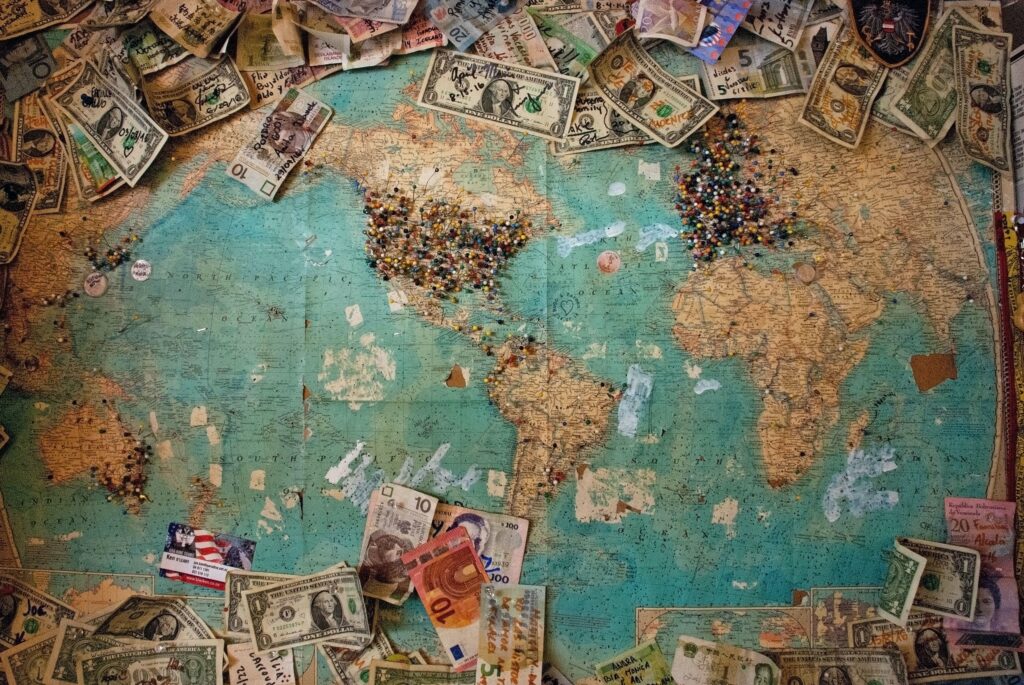 世界地図の上にお金が散らばってる